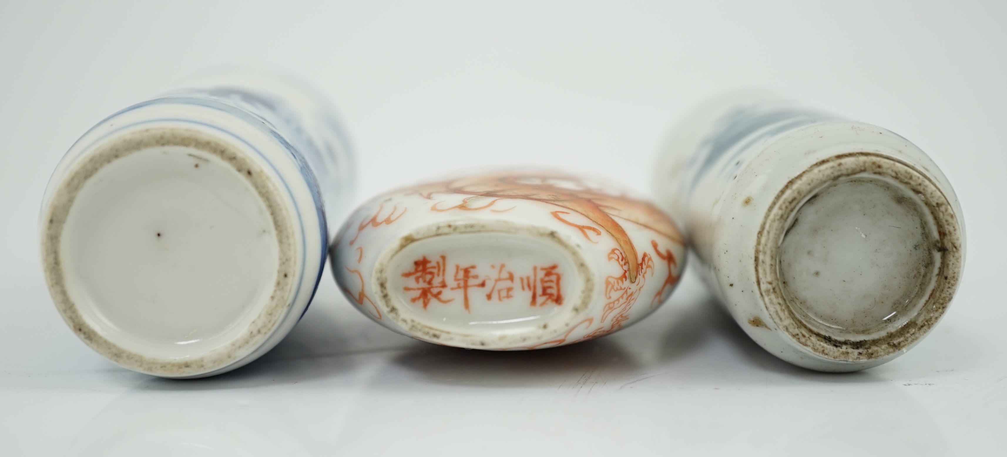 A Chinese iron red enamelled ‘dragon’ snuff bottle, Tongzhi mark and of the period (1862-74), together with two Chinese blue and white cylindrical snuff bottles, 19th century